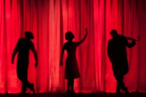 Silhouette of three performing stage actors - Photo by Kyle Head on Unsplash